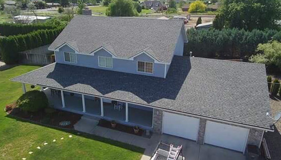 Aerial view of a finished multi-gable asphalt shingle roof with a covered porch
