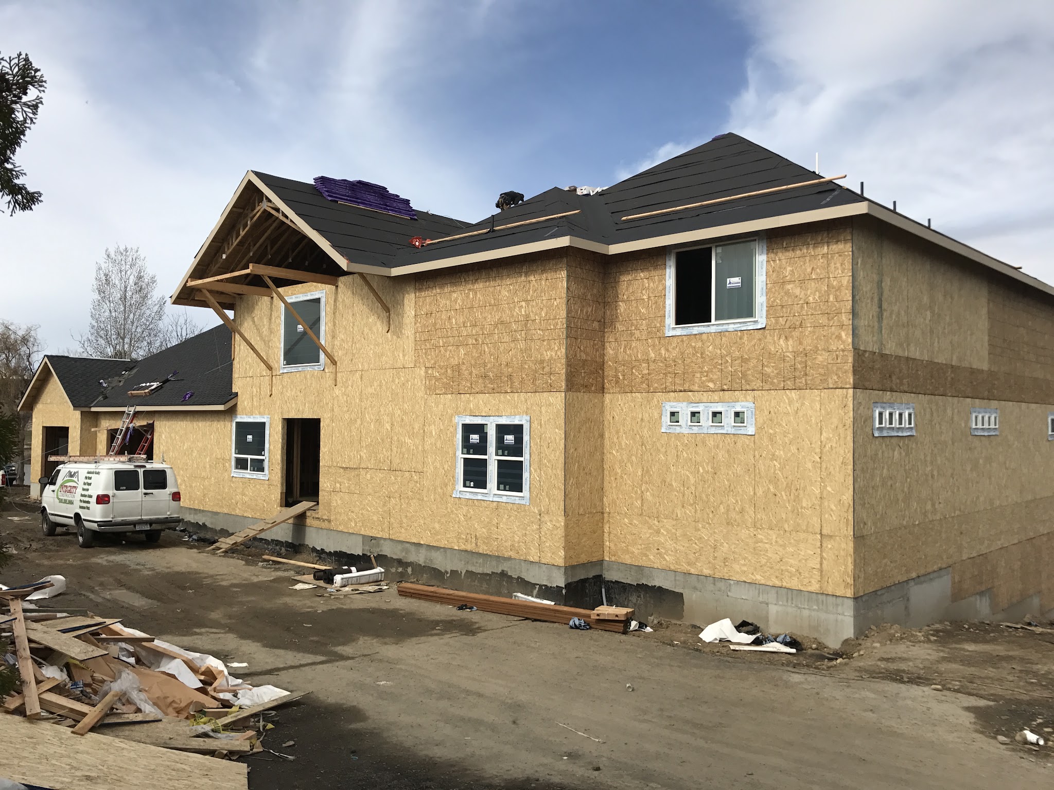 New home under construction with an Integrity Construction company van parked on site